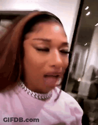 A Close Up Of A Woman Wearing A Pink Shirt And A Necklace . GIF
