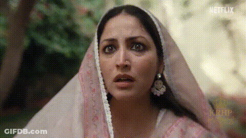 A Close Up Of A Woman Wearing A Pink Veil And Earrings . GIF