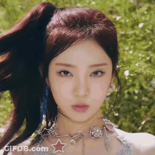 A Close Up Of A Woman Wearing A Ponytail And A Necklace With A Star On It . GIF