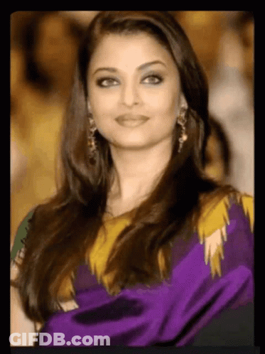 A Close Up Of A Woman Wearing A Purple And Yellow Dress GIF