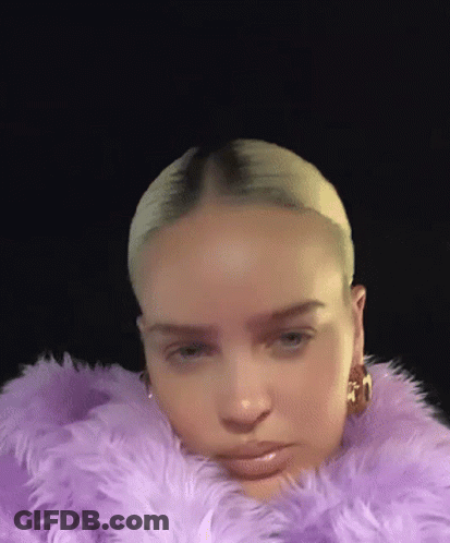 A Close Up Of A Woman Wearing A Purple Fur Coat . GIF