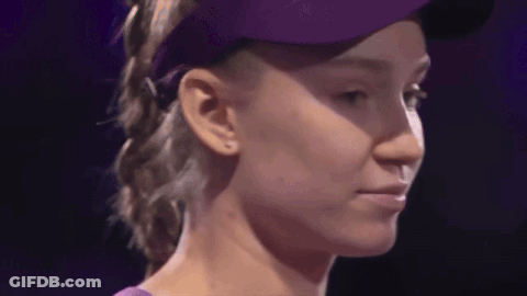 A Close Up Of A Woman Wearing A Purple Hat And A Purple Shirt GIF
