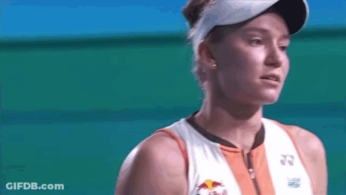 A Close Up Of A Woman Wearing A Red Bull Shirt And Visor GIF