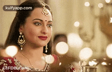 A Close Up Of A Woman Wearing A Red Dress And Jewelry . GIF
