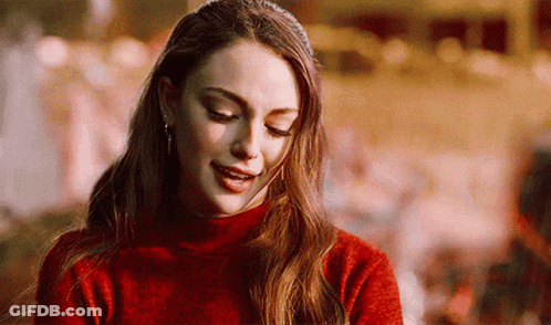 A Close Up Of A Woman Wearing A Red Sweater And Smiling . GIF