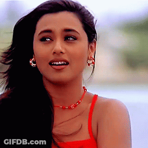 A Close Up Of A Woman Wearing A Red Tank Top And Earrings GIF
