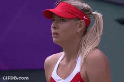 A Close Up Of A Woman Wearing A Red Visor And A Red Tennis Outfit . GIF