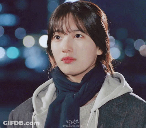 A Close Up Of A Woman Wearing A Scarf And A Hoodie That Says Capture9410 GIF