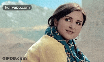 A Close Up Of A Woman Wearing A Scarf And A Yellow Jacket . GIF
