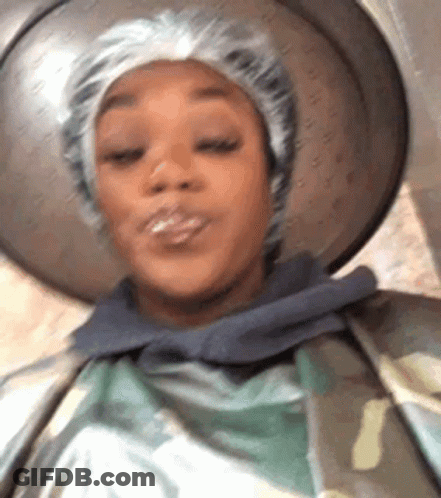 A Close Up Of A Woman Wearing A Shower Cap And A Hat . GIF