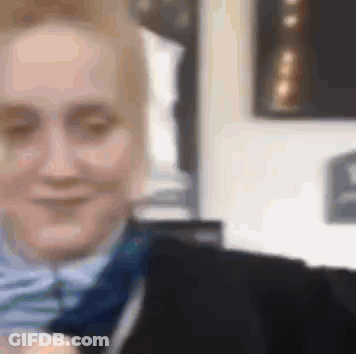 A Close Up Of A Woman Wearing A Suit And Tie Smiling . GIF