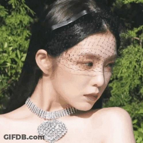 A Close Up Of A Woman Wearing A Veil And A Choker Necklace . GIF