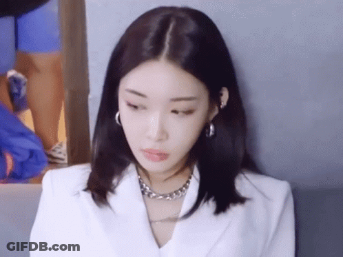 A Close Up Of A Woman Wearing A White Jacket And A Silver Necklace GIF