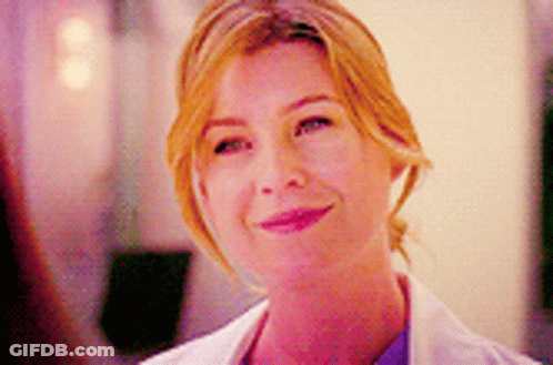 A Close Up Of A Woman Wearing A White Lab Coat And Smiling . GIF