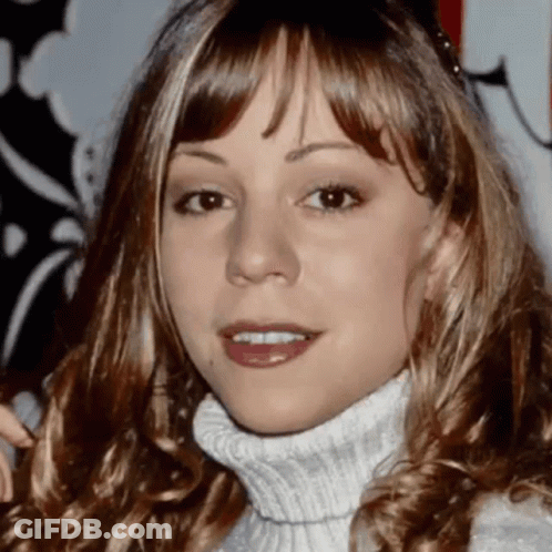 A Close Up Of A Woman Wearing A White Turtleneck GIF