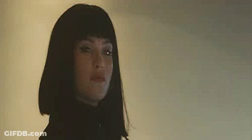 A Close Up Of A Woman Wearing A Wig And A Black Jacket . GIF