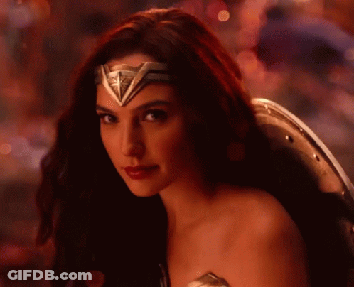 A Close Up Of A Woman Wearing A Wonder Woman Costume And Shield . GIF