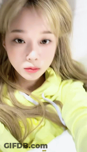 A Close Up Of A Woman Wearing A Yellow Hoodie . GIF