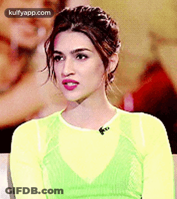 A Close Up Of A Woman Wearing A Yellow Top And A Green Top . GIF