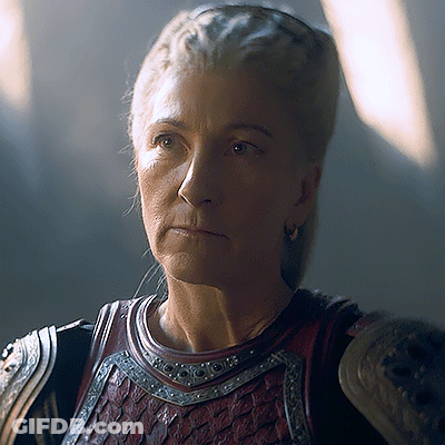 A Close Up Of A Woman Wearing Armor With A Serious Look On Her Face GIF