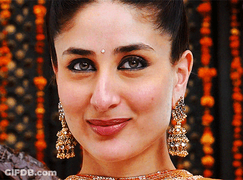A Close Up Of A Woman Wearing Earrings And A Bindi GIF