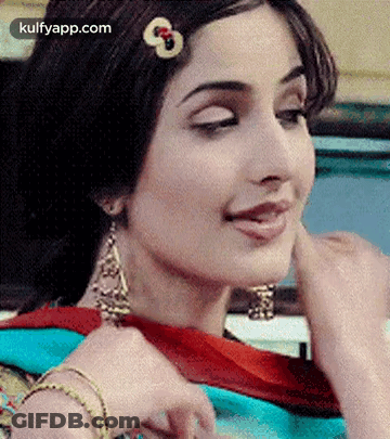 A Close Up Of A Woman Wearing Earrings And A Hair Clip . GIF