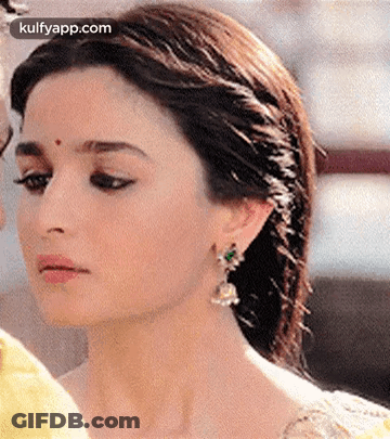 A Close Up Of A Woman Wearing Earrings And A Headband . GIF