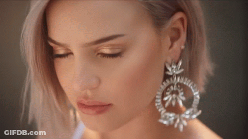 A Close Up Of A Woman Wearing Earrings GIF