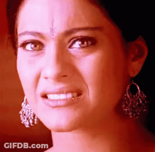 A Close Up Of A Woman Wearing Earrings Making A Face GIF