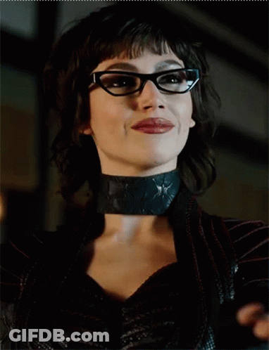 A Close Up Of A Woman Wearing Glasses And A Black Choker GIF