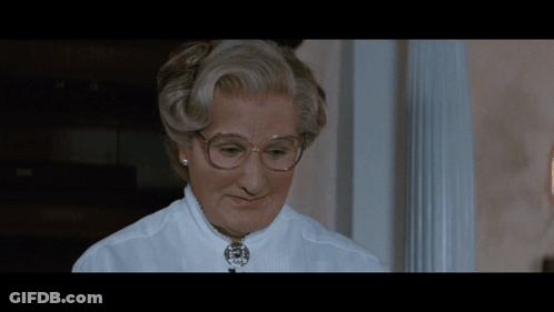 A Close Up Of A Woman Wearing Glasses And A Necklace GIF