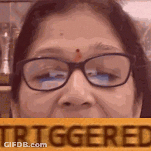 A Close Up Of A Woman Wearing Glasses And Holding A Sign That Says Triggered . GIF