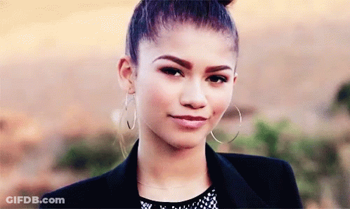 A Close Up Of A Woman Wearing Hoop Earrings And A Jacket GIF
