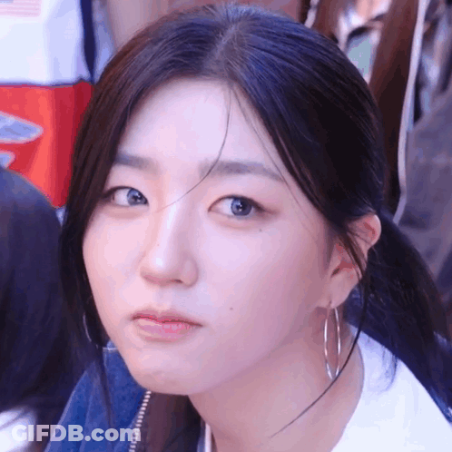 A Close Up Of A Woman Wearing Hoop Earrings And A White Shirt GIF