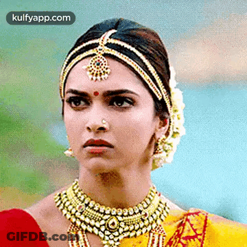 A Close Up Of A Woman Wearing Jewelry And A Headpiece . GIF