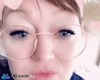 A Close Up Of A Woman Wearing Round Glasses GIF