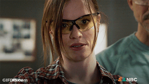 A Close Up Of A Woman Wearing Safety Glasses With A Nbc Logo In The Background GIF