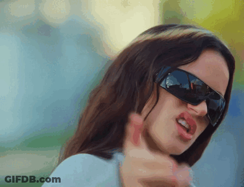 A Close Up Of A Woman Wearing Sunglasses And Making A Funny Face GIF