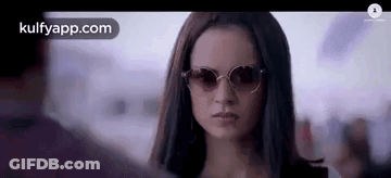 A Close Up Of A Woman Wearing Sunglasses Looking At A Man . GIF