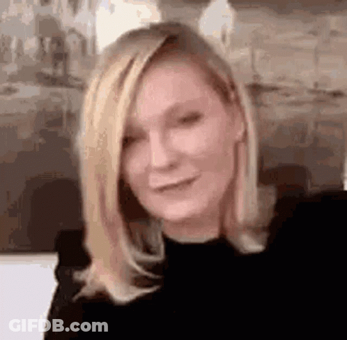 A Close Up Of A Woman With Blonde Hair Wearing A Black Shirt . GIF
