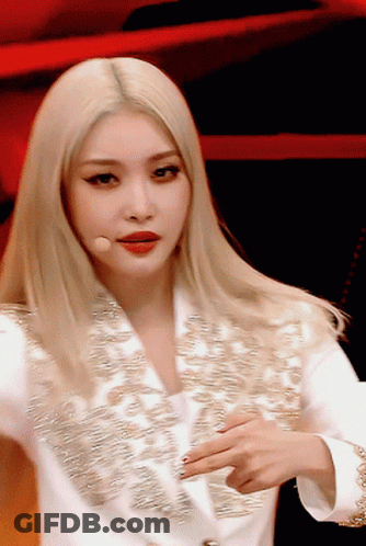 A Close Up Of A Woman With Blonde Hair Wearing A White Jacket GIF
