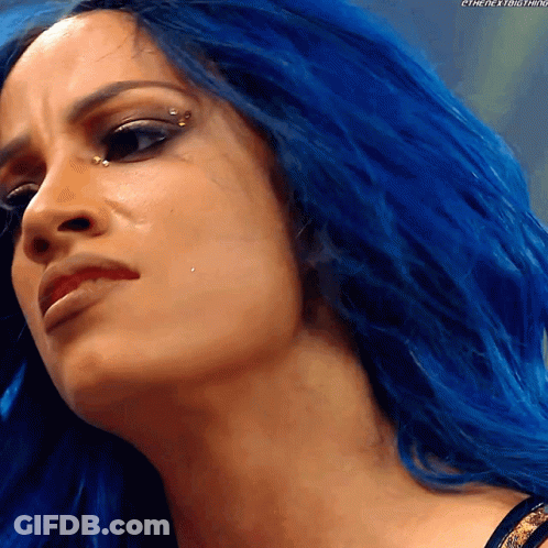 A Close Up Of A Woman With Blue Hair And A Piercing In Her Eye GIF