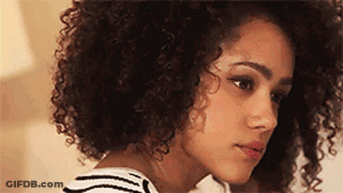 A Close Up Of A Woman With Curly Hair And A Striped Shirt . GIF