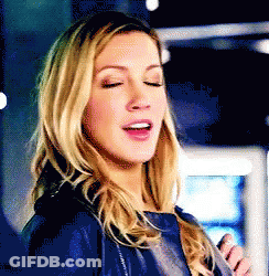 A Close Up Of A Woman With Her Eyes Closed Wearing A Blue Jacket . GIF