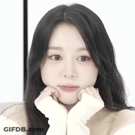 A Close Up Of A Woman With Her Hands On Her Chin GIF