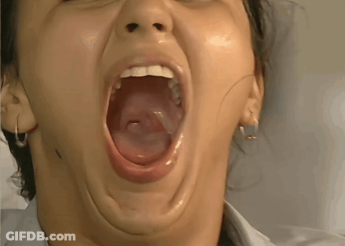 A Close Up Of A Woman With Her Mouth Wide Open GIF