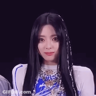 A Close Up Of A Woman With Long Black Hair Wearing A Blue And White Outfit . GIF