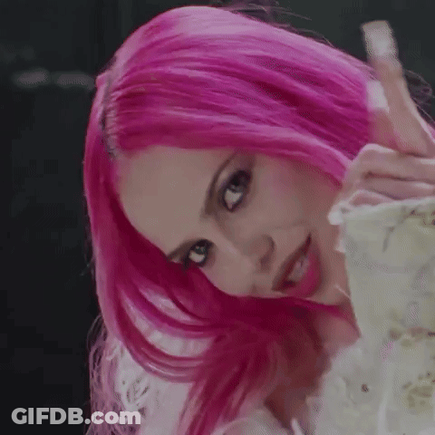 A Close Up Of A Woman With Pink Hair Covering Her Face With Her Hands . GIF