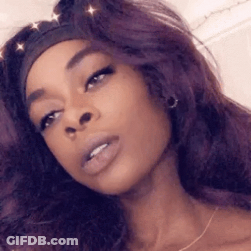 A Close Up Of A Woman With Purple Hair Wearing A Headband . GIF
