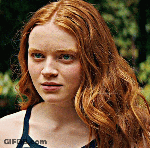 A Close Up Of A Woman With Red Hair And Blue Eyes GIF